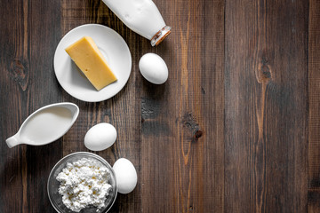 Obraz na płótnie Canvas Natural food. Milk, cottage, cheese, eggs on dark wooden background top view copyspace