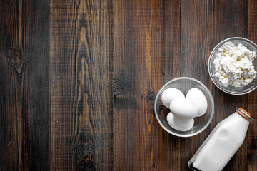 Non GMO, prservatives-free organic food. Milk, cottage, eggs on dark wooden background top view copyspace