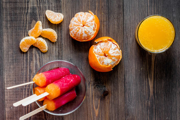 Orange juice, mandarins and citrus ice cream on wooden table background top view copyspace
