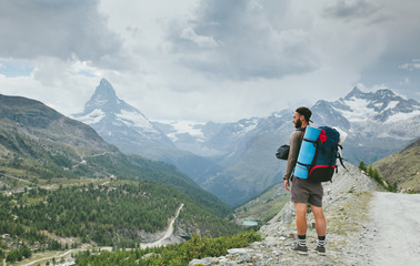Fototapeta na wymiar Man hiking to Matterhorn Mountain in summer in Zermatt city, Switzerland