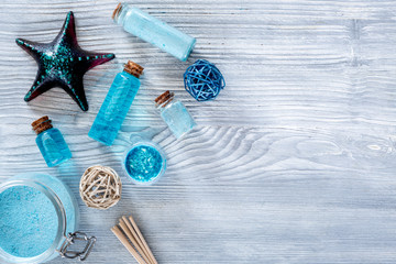 Sea cosmetics. Sea salt, blue clay and lotion on wooden background top view copyspace
