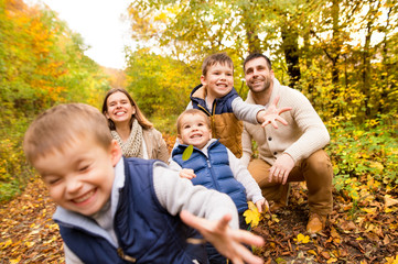 Fototapeta premium Beautiful young family on a walk in autumn forest.