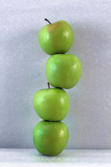 stack of green apples on grey background. the concept of balancehealthy lifestyle and team work
