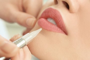 Young woman having permanent makeup on lips in beautician salon, closeup - obrazy, fototapety, plakaty