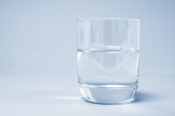 Glass with water on a blue background