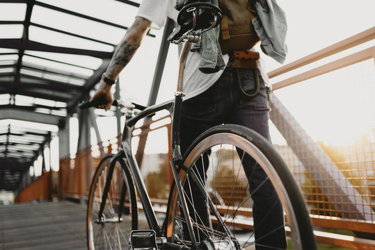 Radfahrer f&auml;hrt mit Singlespeed bei Sonnenuntergang durch die Stadt