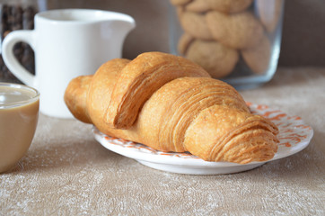 Delicious continental breakfast with fresh flaky croissants, coffee with milk