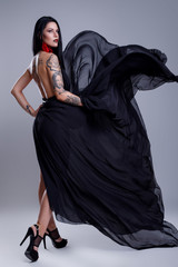 Woman with tattoos wearing black dress