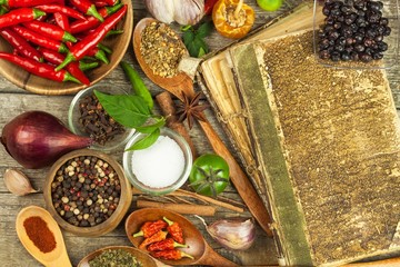 Old book of cookery recipes. Culinary background and recipe book with various spices on wooden table.