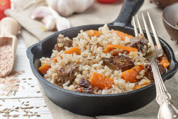 Devzira pilaf with lamb, onions, carrots and spices (cumin, coriander, pepper). Traditional dishes of Uzbek cuisine. Selective focus
