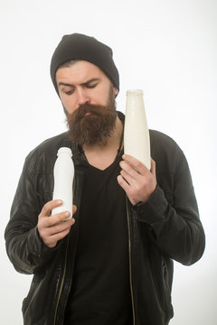 Man with long beard hold milk bottle.