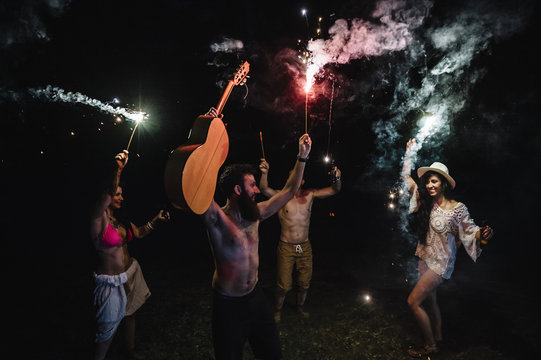 Friends playing with sparkles at the night