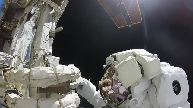 Astronaut fixes satellite in space, close up
