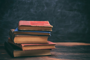 Vintage books stack on blackboard background