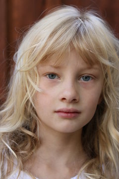 Close up portrait of a young blonde blue eyed girl