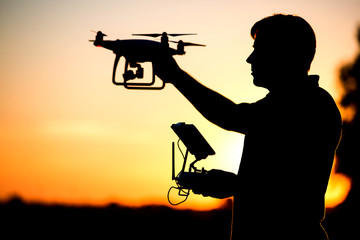 Young man operating of flying drone the setting sun © Rakursstudio