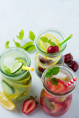 Fototapeta na wymiar Refreshing summer homemade cocktail in glass bottles. Detox fresh water. Selective focus. Copy space.