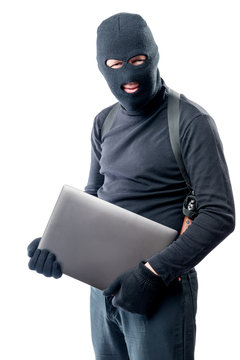 Thief in a balaclava with a laptop on a white background