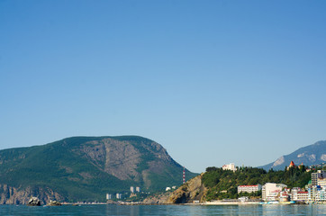 Fototapeta premium Mountain standing with a resort town by the sea