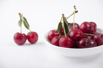 Cherries in a white plate on a white background