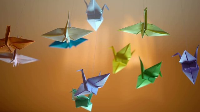 Colorful origami birds background, paper cranes swaying in the wind, relaxation

