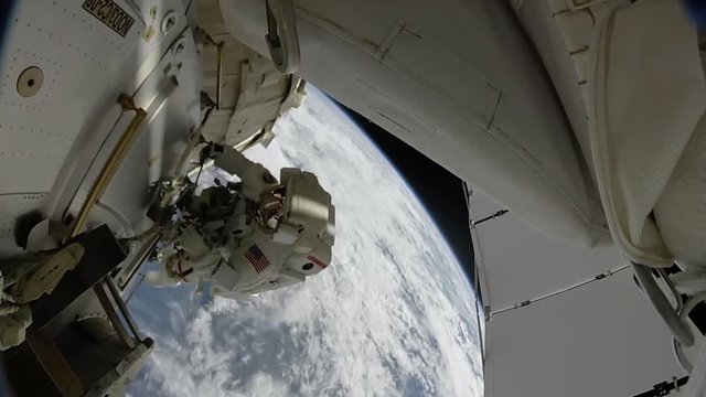 Astronaut outside space station over Earth