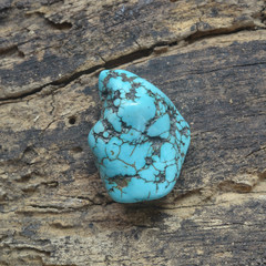 Raw turquoise gemstone rock isolated on wood