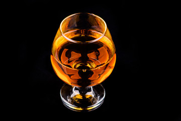 glass with cognac on a black background
