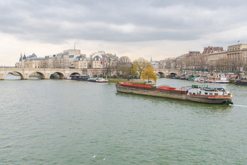 Fototapeta na wymiar Paris, view of the Seine from the pont des Arts, with the Pont-Neuf and a barge crossing 