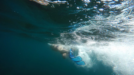 swimmer in flippers dives into the sea