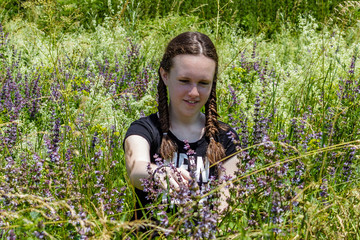 Smiling young girl with hair braids in floral field