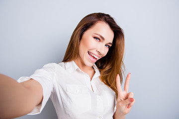 Selfie time! Funky mood. Attractive young lady is making a selfie on the camera, flirty and...