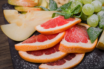 Fruit slicing on a wooden background and on a stone stand