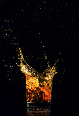 Isolated shot of whiskey with splash on black background
