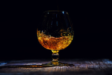 glass with cognac on a wooden background