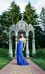 Beautiful young fashion woman in blue color dress posing outdoor