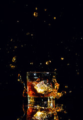 Isolated shot of whiskey with splash on black background