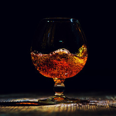 glass with cognac on a wooden background