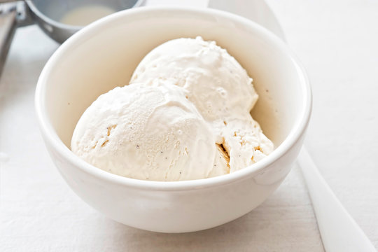 Vanilla ice cream scoops in white bowl 
