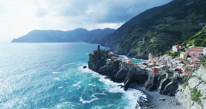 aerial view of travel landmark destination Vernazza,small mediterranean sea town,Cinque terre National Park, Liguria, Italy. Afternoon sunny and cloud weather. 4k slow motion 60 fps drone side video
