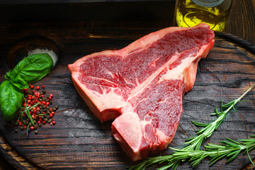 Raw T-bone steak with herbs