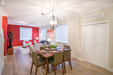 Interior design of a modern dining room with a living room in the background.
