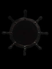 The ship's wheel on a black background