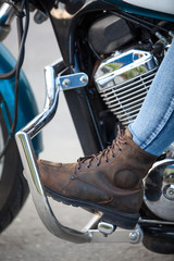 Fototapeta na wymiar Motorcycle boot on the footboard of a motorcycle, close-up
