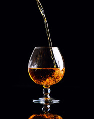 glass with cognac on a black background