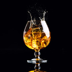glass with cognac on a black background