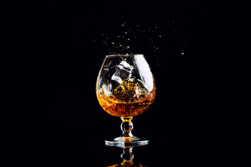 glass with cognac on a black background