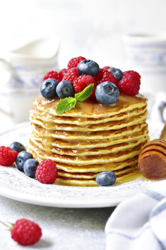 Homemade pancakes with honey and fresh berries.