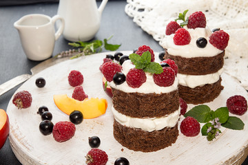 Chocolate cake decorated with raspberry, black currant, nectarine, wipped cream and mint.