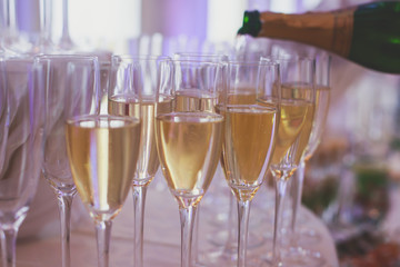 Line of different colored alcohol cocktails on a decorated catering banquet table on a party